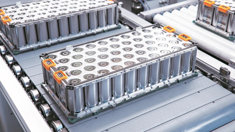 Engineers supervising an automated battery cell welding line